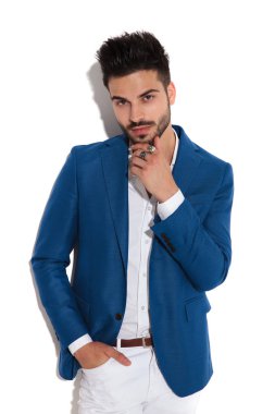 Şaşkın adam kameraya bakıyor ve çenesini dokunuyor