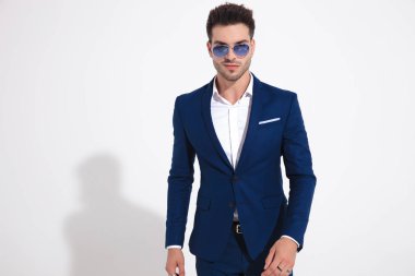 Sert genç adam cesurca kameraya yürüyor 