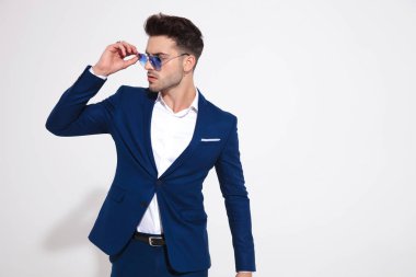 Ciddi görünümlü genç adam onun güneş gözlüğü sabitleme