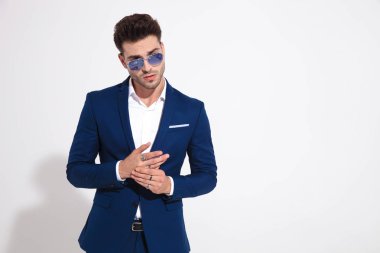 Yakışıklı adam yan bakıyor ve onun yüzük ayarlama 