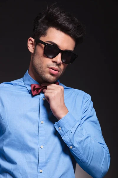 Attractive young guy fixing his bowtie — Stock Photo, Image