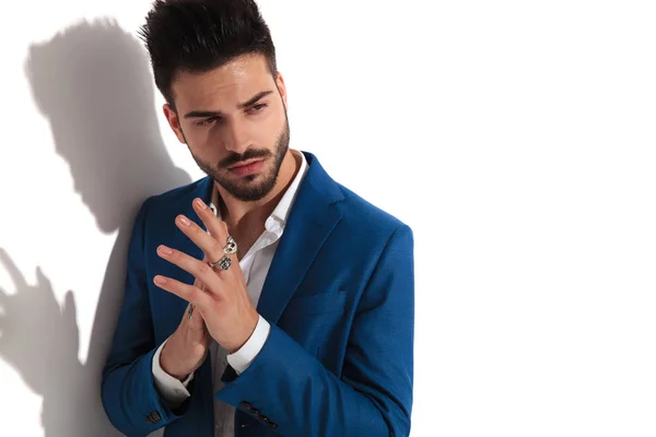 Close up of a thoughtful young man rubbing his hands — Stock Photo, Image