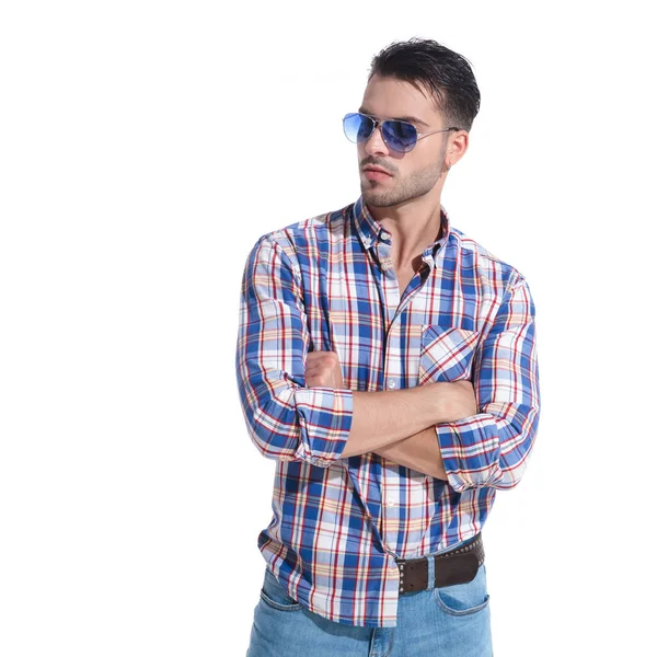 Serious looking man staring sideways with his arms folded — Stock Photo, Image