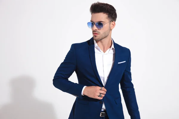 Fashion model looking to the side and fixing his jacket — Stock Photo, Image