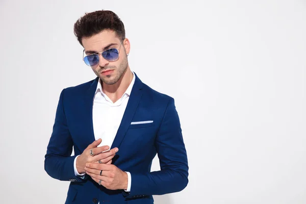 Mystified fashion model looking away and fixing his rings — Stock Photo, Image