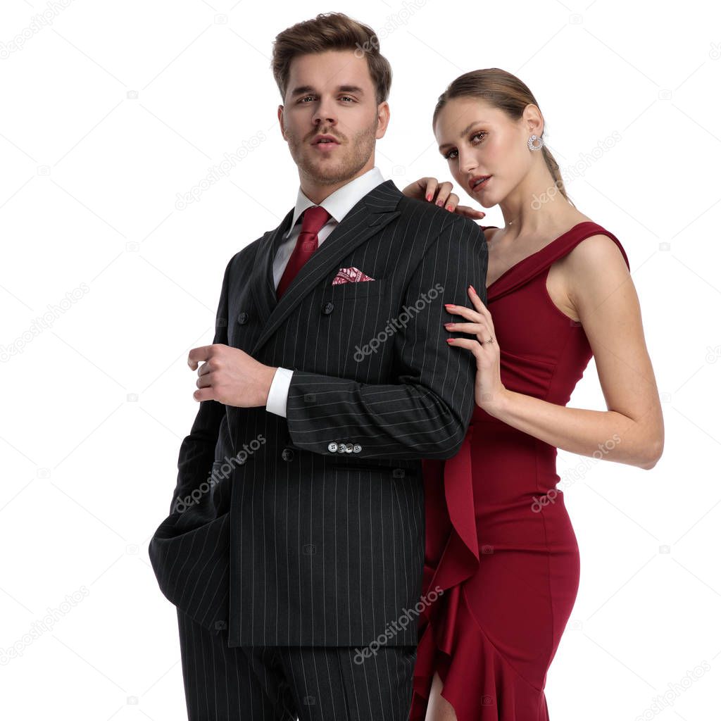 Confident couple staring at the camera and being dressed elegant