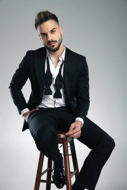 Çekici adam oturan ve gözlük tutan