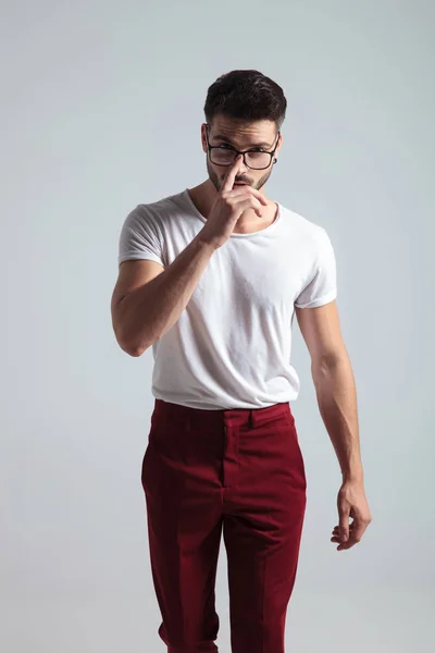 Hombre decidido caminando hacia adelante y ajustando sus gafas — Foto de Stock