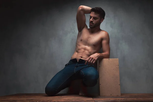 Sensuell ung kille kneeing och lutar på en låda — Stockfoto