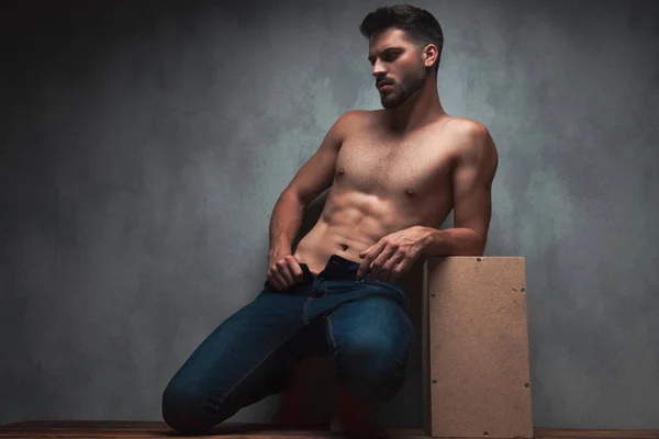 Charmoso homem de topless posando e puxando seus jeans — Fotografia de Stock