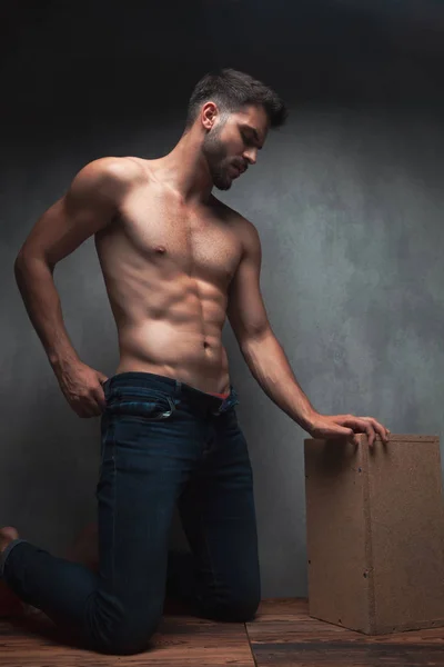 Betrokken sexy man het aanpassen van zijn jeans en kneeing — Stockfoto