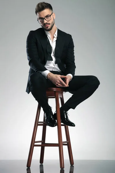 Guilty looking man sitting on a stool — Stock Photo, Image