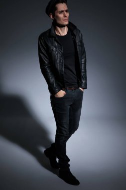 Etkilenmemiş adam adım ve ceplerinde ellerini tutarak