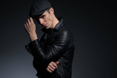 Sert genç adam şapkasını ayarlıyor ve kaşlarını çattı 