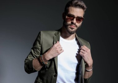 Yeşil ceketinin yakasını ayarlayan kararlı adamın yakın çekim