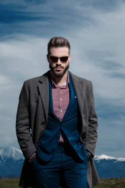 Güçlü işadamı iki elini cebinde tutuyor