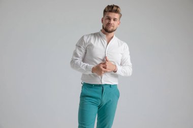 Kendinden emin tombul adam ellerini ovuşturarak ve ileriye bakıyor