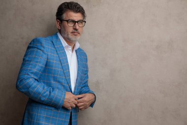 Yan bakarken ceketini ayarlayan üzgün işadamı