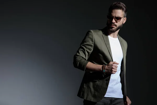 Dramatic man holding his hand on his green jacket's collar — Stock Photo, Image