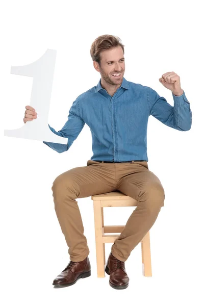 Homem feliz segurando um número um e comemorando — Fotografia de Stock