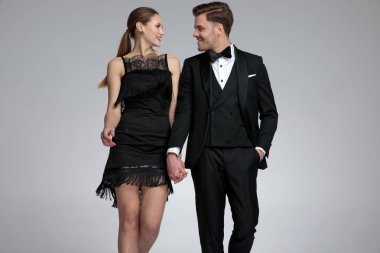 Mutlu genç çift eller tutarak ve gülüyor