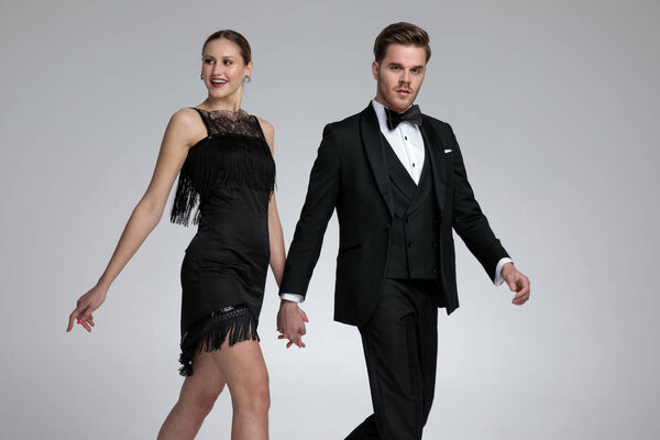 Счастливая пара, идущая в сторону и держащаяся за руки
 