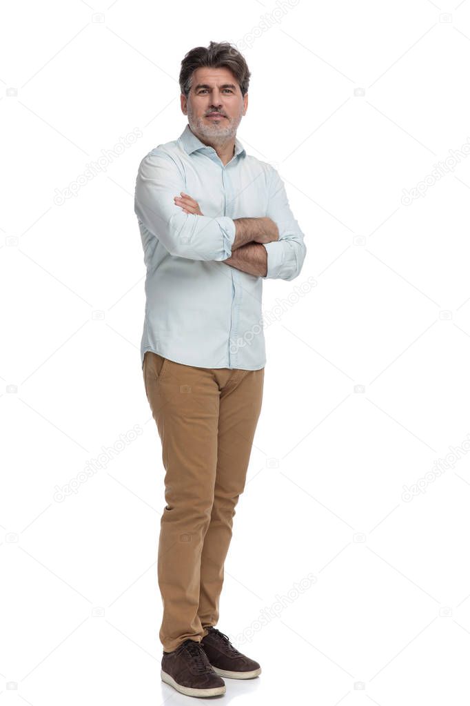 Confident casual old man standing with his arms folded