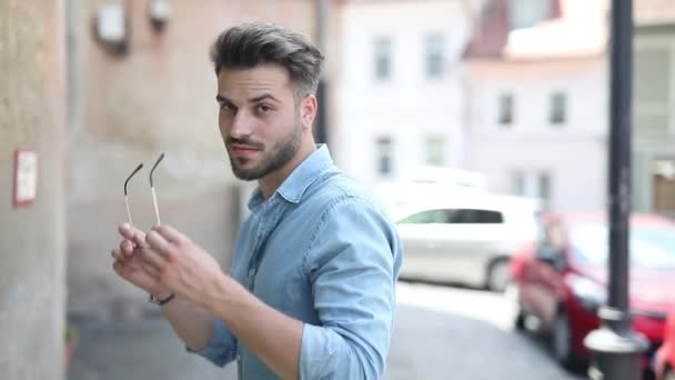 Arrogant young man fixing his shirt's collar and snapping his fingers — Stock Video