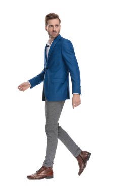 Endişeli rahat adam omzunun üzerinden bakıyor ve yürüyor 