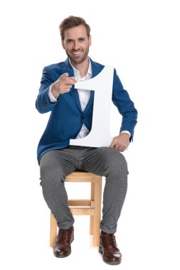 Gündelik adam kamera işaret ve bir numara tutarak