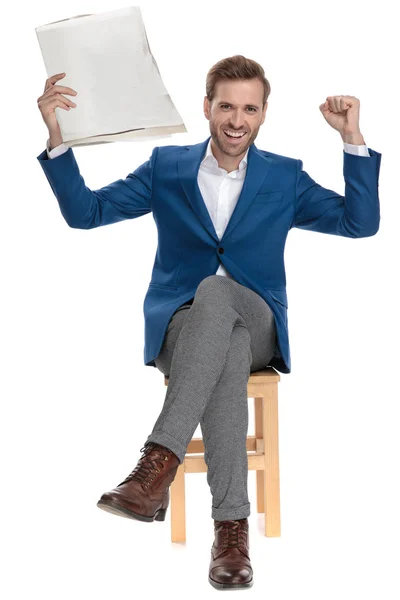 Alegre hombre casual celebrando con un periódico en la mano —  Fotos de Stock