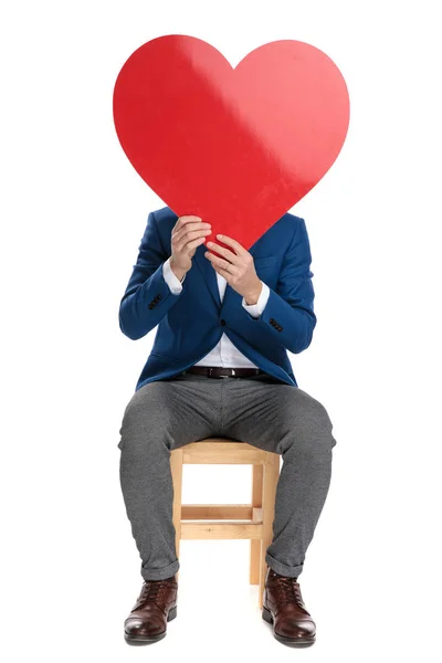 Příležitostný chlapík držící v obličeji tvar srdce — Stock fotografie