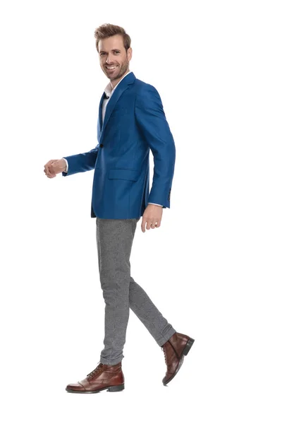 Side view of a positive casual guy smiling and walking — Stock Photo, Image