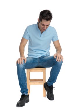 Hevesli rahat adam aşağı bakıyor ve gülümsüyor 