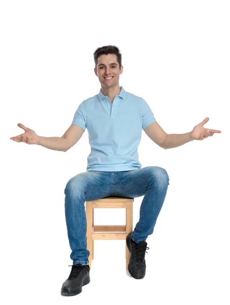 긍정적 인 젊은 남자 앉아 와 그의 팔 을 크게 벌리고 — 스톡 사진