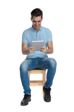 Pozitif genç adam gülümseyen ve masasına bakıyor