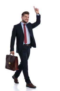 Yakışıklı işadamı yürüyor ve çantasını tutuyor 