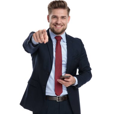 Neşeli işadamı işaret ve telefonunu tutarak