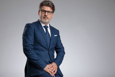 Zarif bir mavi giyerken ciddi görünümlü businessmn oturuyor