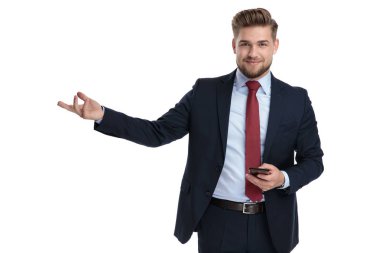 Kendine güvenen işadamı telefonunu takdim ediyor ve tutuyor 