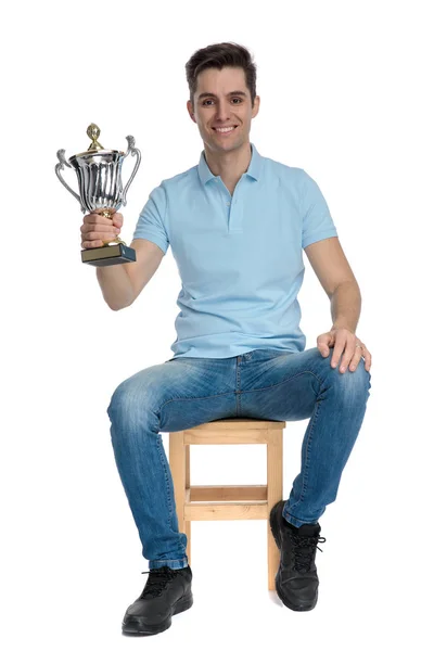 Bonito cara casual sorrindo e segurando seu troféu — Fotografia de Stock