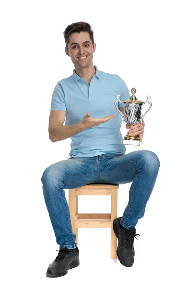 Jovem feliz apresentando seu troféu e sorrindo — Fotografia de Stock