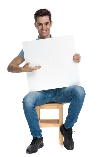 Fröhlicher, lässiger Typ, der präsentiert und leere Plakatwände — Stockfoto