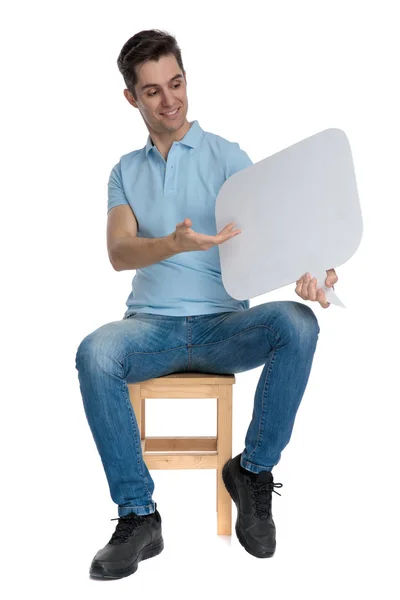 Hombre casual confiado presentando una burbuja de habla en blanco y una sonrisa — Foto de Stock