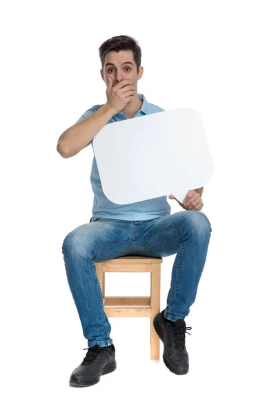 Ragazzo stupito coprendo la bocca e tenendo una bolla discorso — Foto Stock