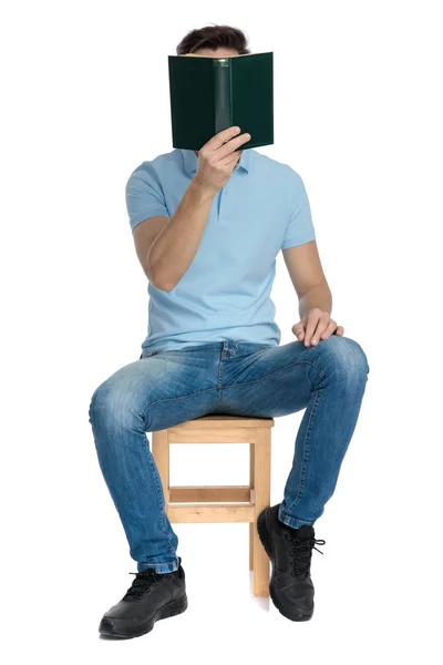 Casual kerel bedekt zijn gezicht met een boek — Stockfoto