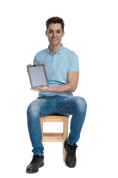 Jovem confiante apresentando seu tablet em branco e sorriso — Fotografia de Stock