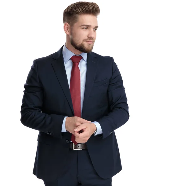 Young businessman adjusting his sleeve and looking to the side — Stock Photo, Image