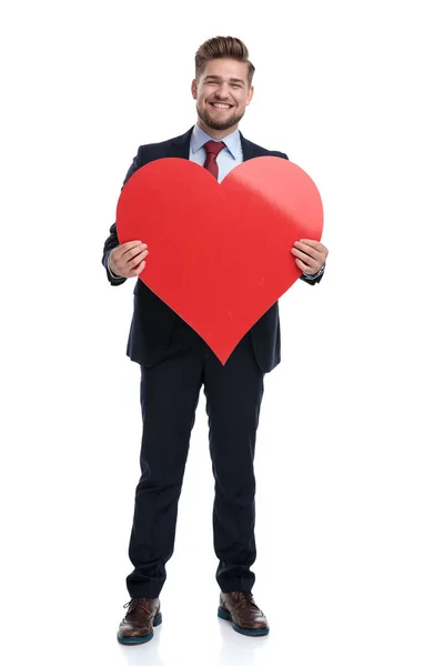 Happy businessman laughing and holding a big heart shape — Stock Photo, Image