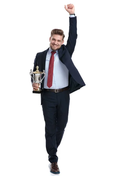 Zwycięski biznesmen obchodzi i trzyma trofeum — Zdjęcie stockowe